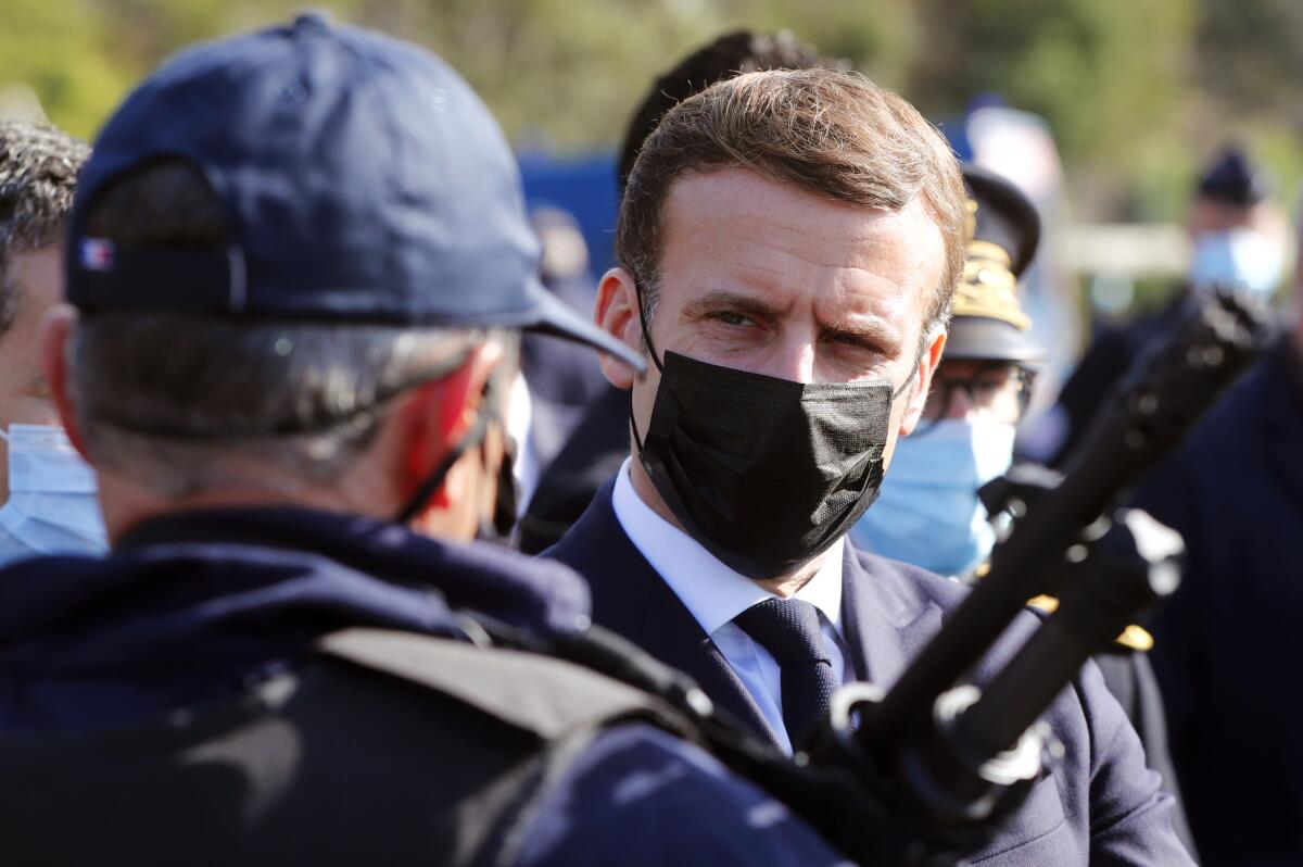 French President Emmanuel Macron speaks with a police officer