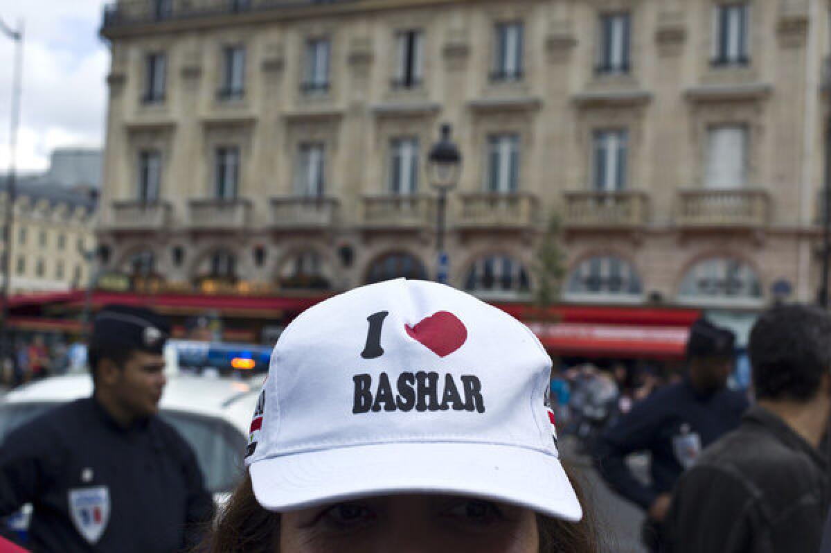 A protester wears a cap declaring "I [heart] Bashar" during a demonstration in Paris on Saturday against French and foreign military involvement in Syria.