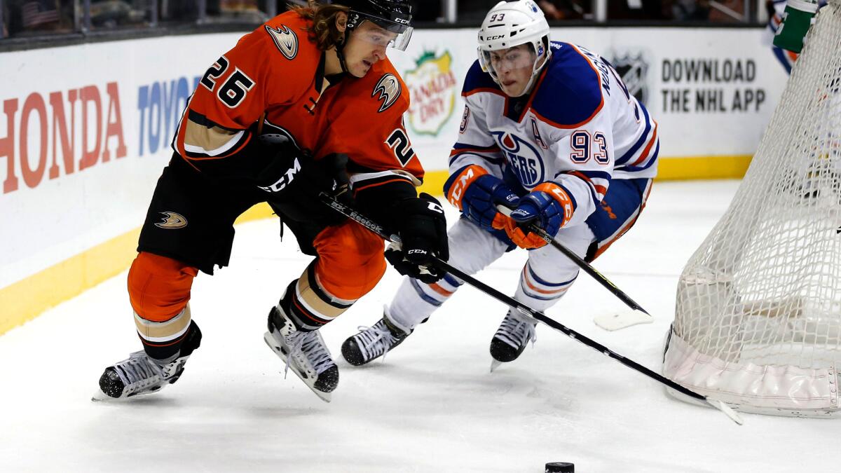 Ducks left wing Carl Hagelin brings the puck around the goal against Oilers center Ryan Nugent-Hopkins during a game Nov. 11 in Edmonton.
