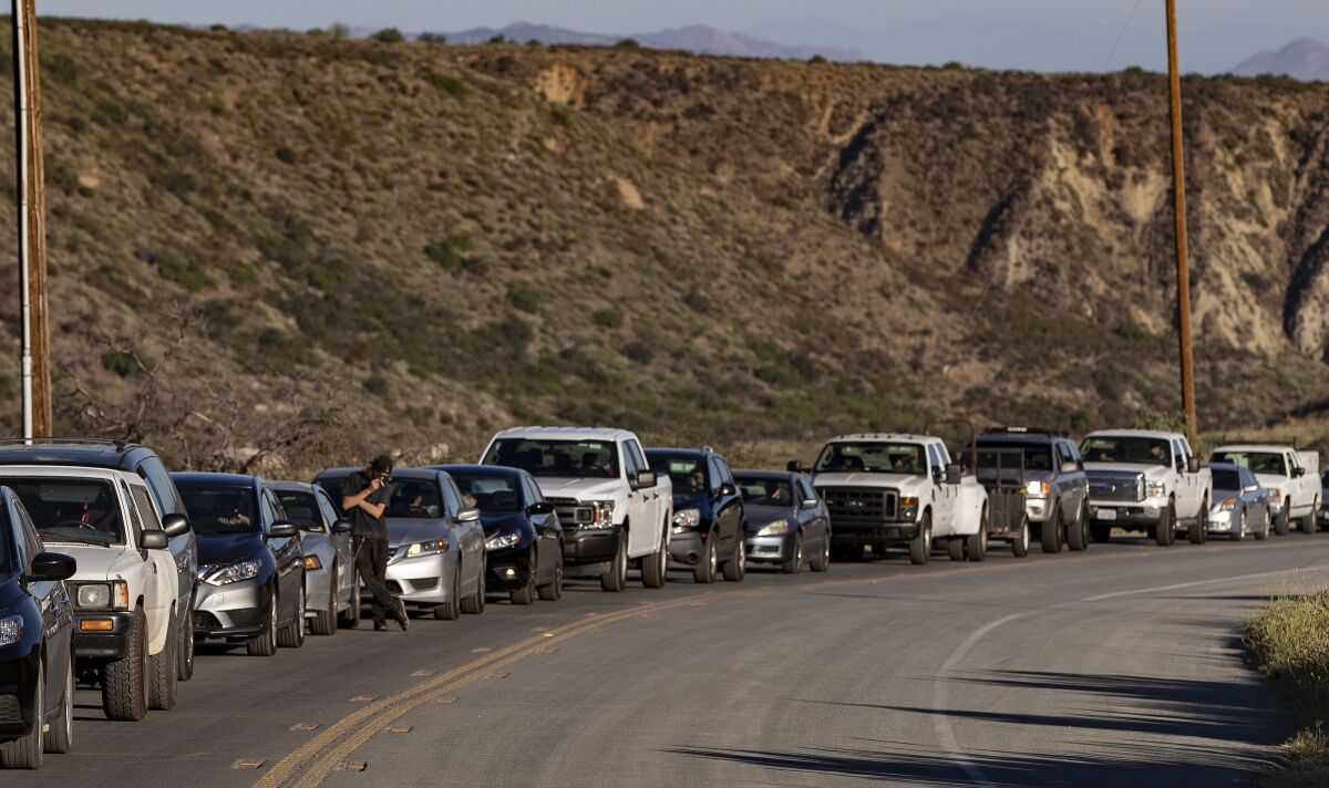 Drivers wait for a pilot vehicle to be escorted up Highway 74 in the morning to get to Idyllwild.
