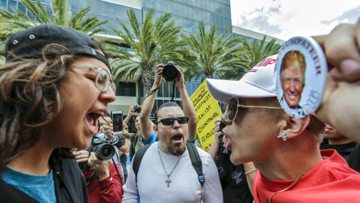 Jake Towe, simpatizante de Donald Trump, a la derecha, discute acaloradamentecon Joshua González, a la izquierda, en el Centro de Convenciones de Anaheim, donde Donald Trump tuvo un acto de campaña.