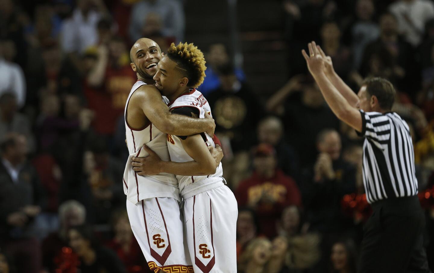 Trojans guards Julian Jacobs, left, and Jordan McLaughlin celebrate after making one final three-pointer during an 80-61 victory over the Bruins on Thursday night at the Galen Center.