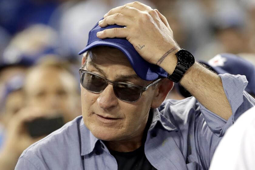 FILE - In this Oct. 19, 2016, file photo, actor Charlie Sheen reacts during the fifth inning of Game 4 of the National League baseball championship series between the Chicago Cubs and the Los Angeles Dodgers in Los Angeles. Sheen hasn't portrayed Babe Ruth in a film, but the actor was the owner of two of the most prized items of Ruth memorabilia. Sheen on Monday, June 26, 2017 revealed himself as the owner of Ruth's 1927 World Series ring and the 1919 contract of Ruth's sale from the Red Sox to the Yankees which are part of the first Lelands.com Invitational Auction, which ends on Friday. (AP Photo/David J. Phillip, File)