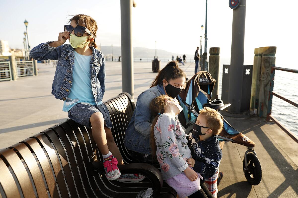 Masked children sit with their nanny.