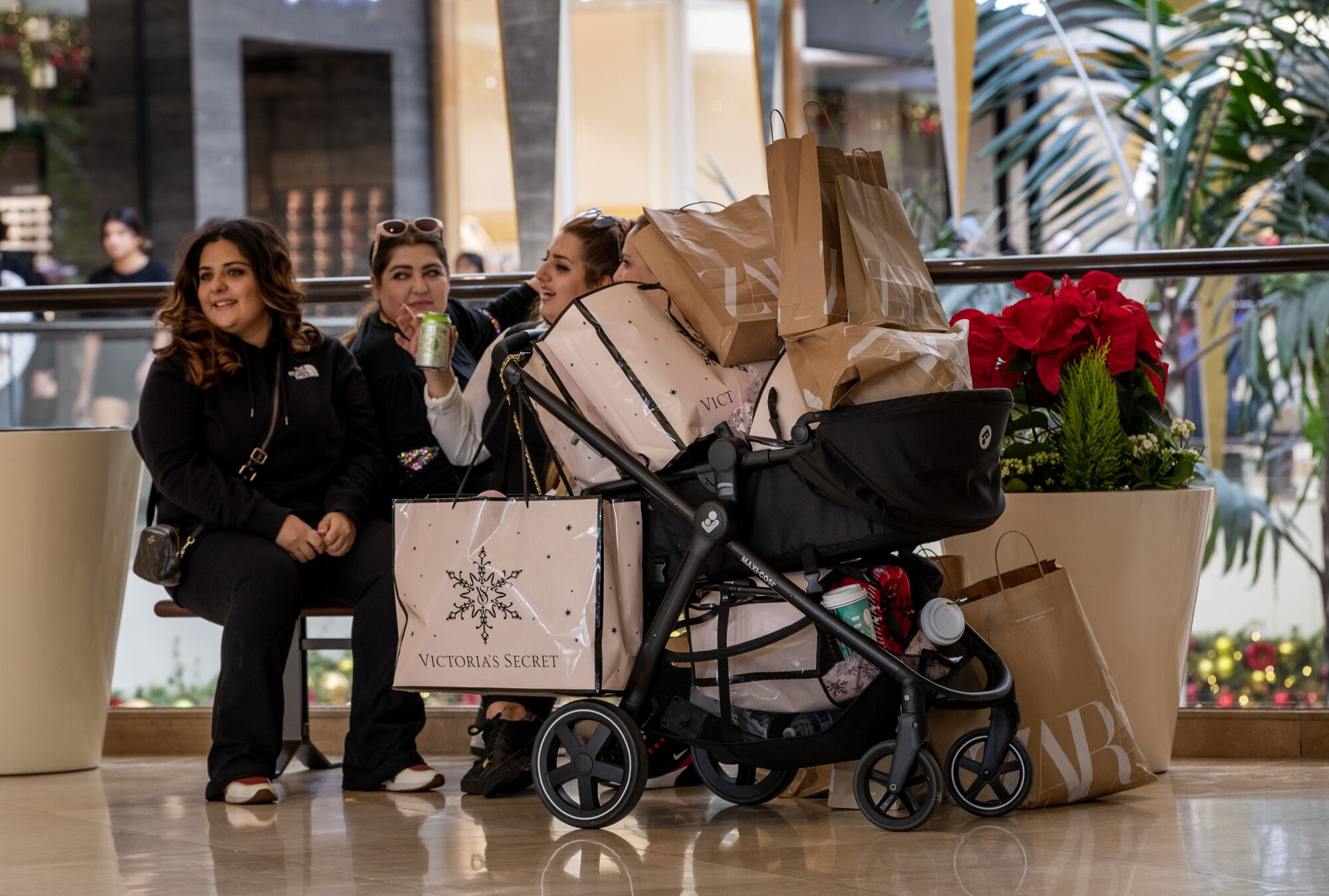 The Naybe family of Irvine takes a break after a shopping spree on Friday at South Coast Plaza in Costa Mesa.