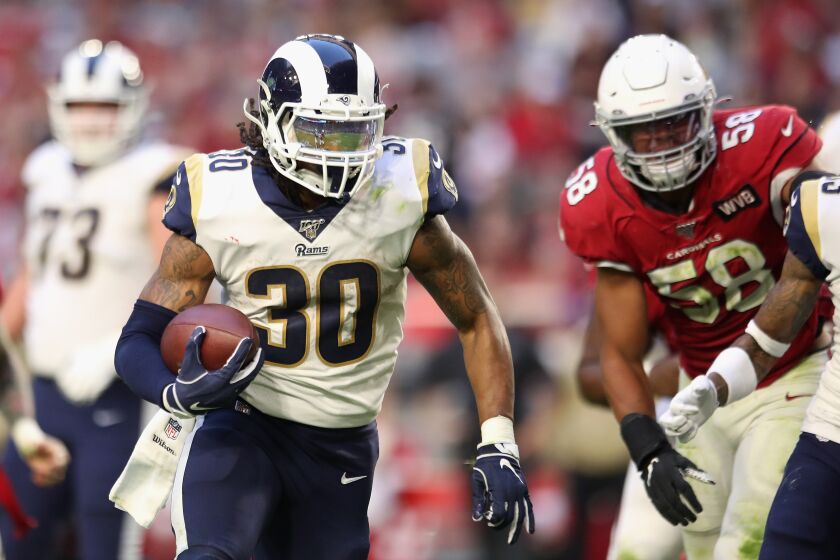GLENDALE, ARIZONA - DECEMBER 01: Running back Todd Gurley #30 of the Los Angeles Rams rushes the football past middle linebacker Jordan Hicks #58 of the Arizona Cardinals during the second half of the NFL game at State Farm Stadium on December 01, 2019 in Glendale, Arizona. The Rans defeated Cardinals 34-7. (Photo by Christian Petersen/Getty Images)