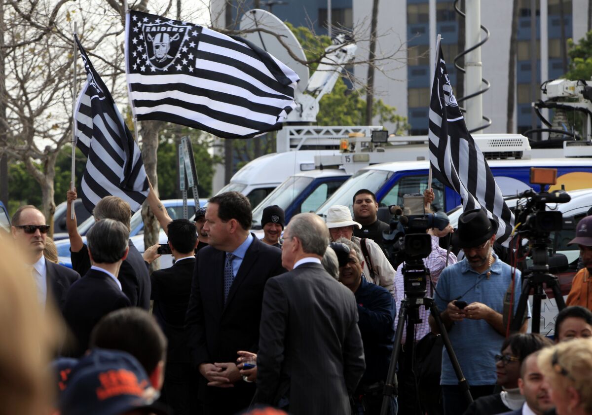 Raiders fans wave flags during the news conference announcing the Oakland-San Diego plan to build an NFL stadium in Carson.