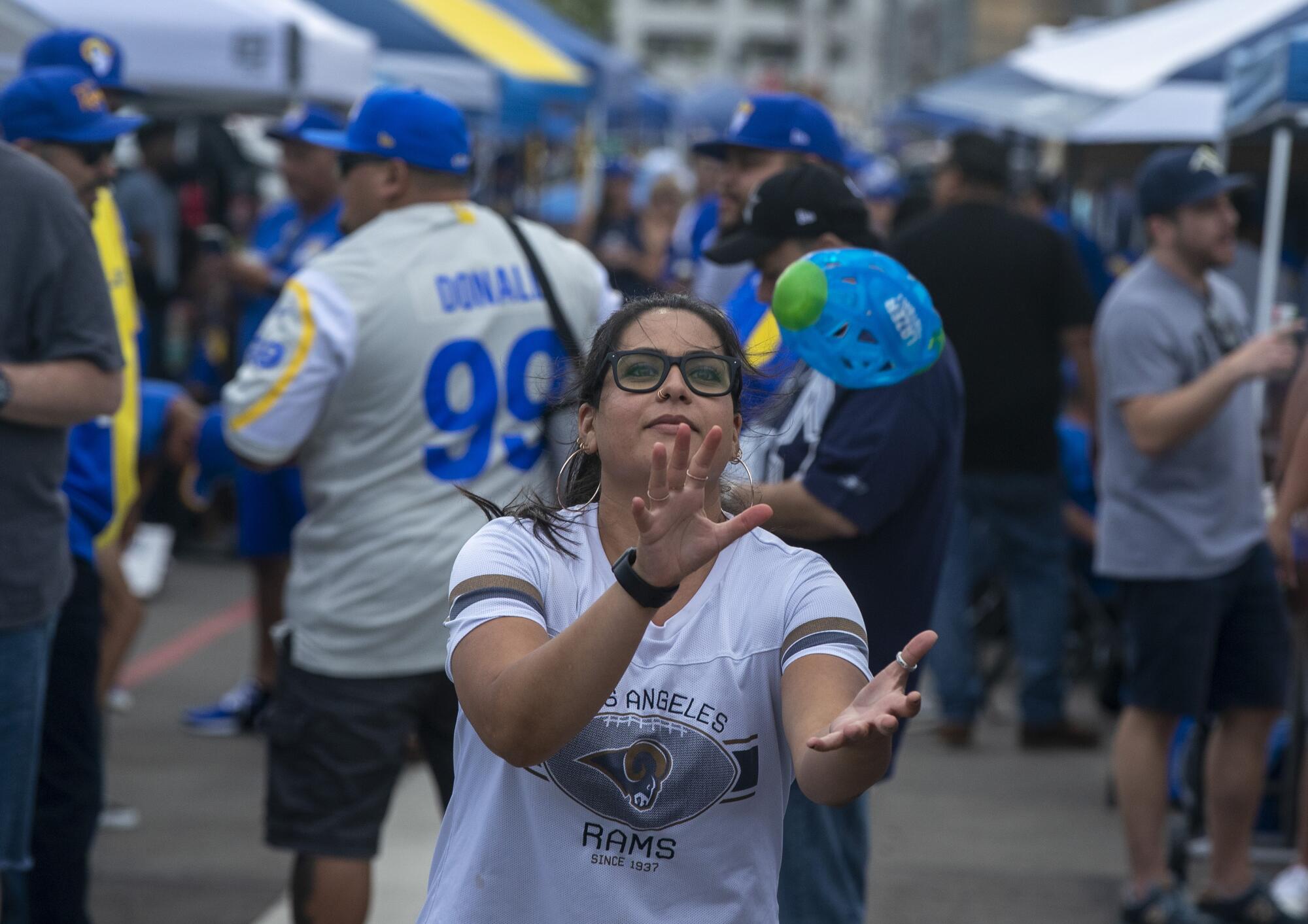  Briana Romo of Los Angeles plays catch while tailgating before the preseason game.