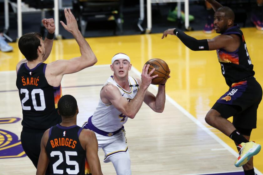 LOS ANGELES, CA - MAY 09: Los Angeles Lakers guard Alex Caruso (4) is guarded under the basket by Phoenix Suns forward Dario Saric (20), Phoenix Suns forward Mikal Bridges (25) and Phoenix Suns guard Chris Paul (3) in the second quarter at the Staples Center on Sunday, May 9, 2021 in Los Angeles, CA. (Gary Coronado / Los Angeles Times)