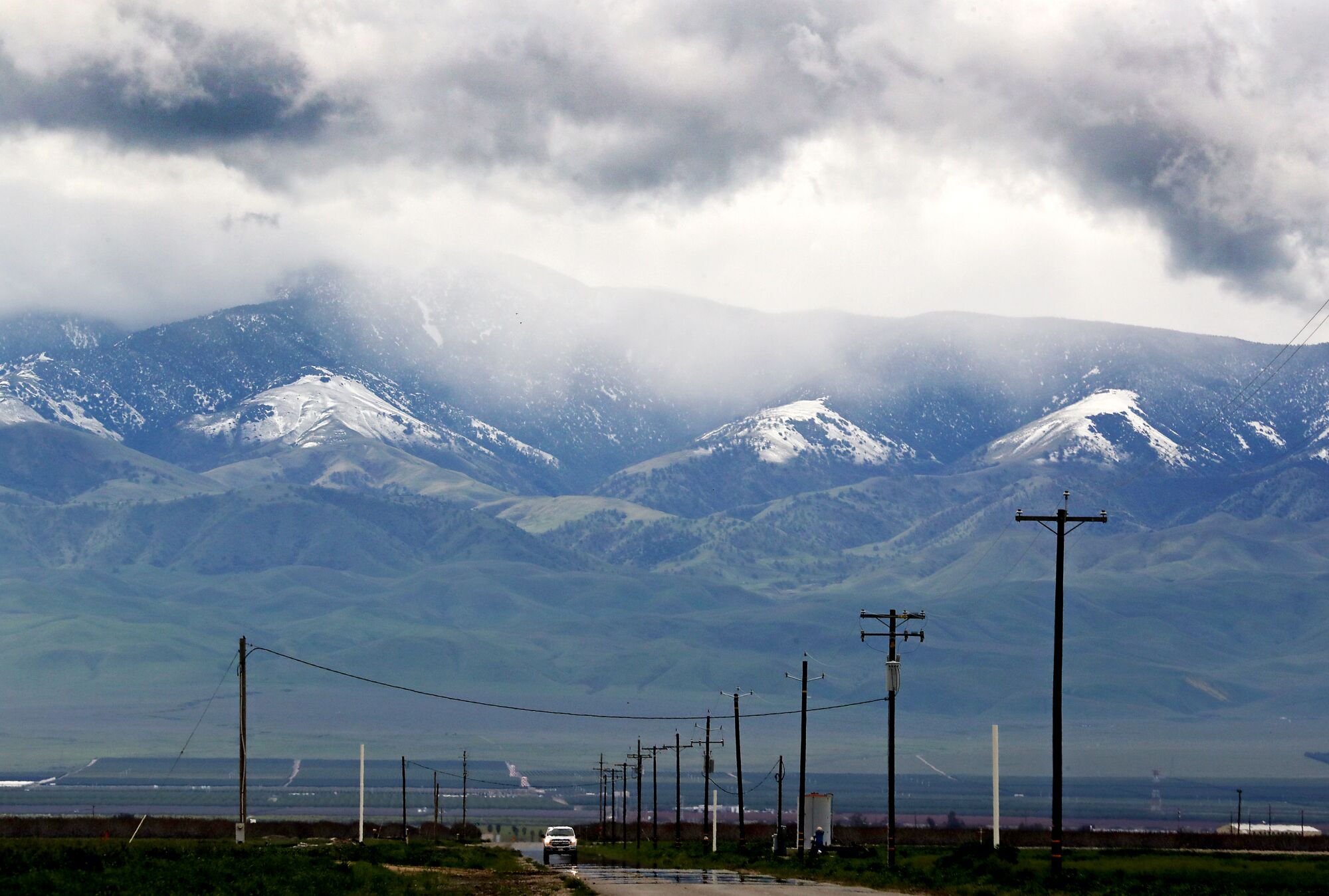 Storm clouds leave a dusting of snow on the mountains at the edge of the vast and fertile San Joaquin Valley. 
