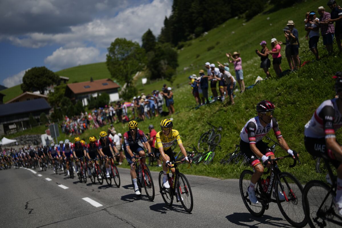 UAE Team Emirates riders, right, set the pace for their leader Slovenia's Tadej Pogacar, wearing the overall leader's yellow jersey, as they climb during the ninth stage of the Tour de France cycling race over 193 kilometers (119.9 miles) with start in Aigle, Switzerland and finish in Chatel les Portes du Soleil, France, Sunday, July 10, 2022. (AP Photo/Thibault Camus)