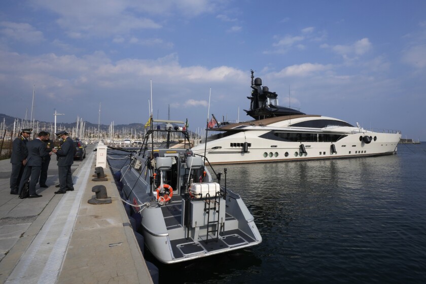 Italian Finance Police stand by the yacht "Lady M", owned by Russian oligarch Alexei Mordashov, docked at Imperia's harbor, Italy, Saturday, March 5, 2022. European governments are moving against Russian oligarchs to pressure Russian President Vladimir Putin to back down on his war in Ukraine, seizing superyachts and other luxury properties from billionaires on sanctions lists. (AP Photo/Antonio Calanni)