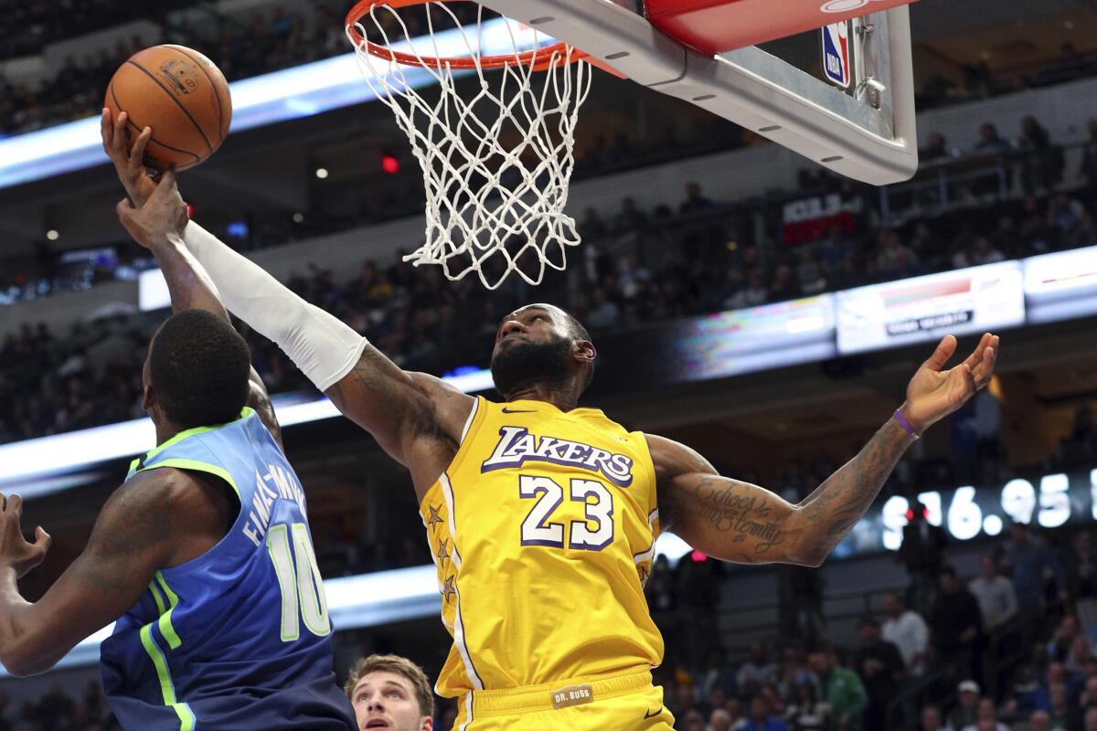 Lakers forward LeBron James attempts a reverse layup against Mavericks forward Dorian Finney-Smith on Jan. 10, 2020, in Dallas.