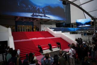 Festival workers lay the red carpet at the Palais des Festivals on opening day of the 77th international film festival,