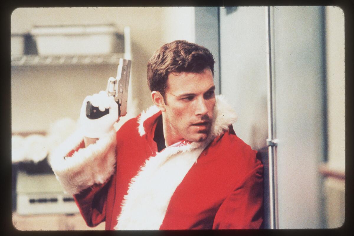 Ben Affleck in wearing a Santa suit and holding a gun in "Reindeer Games" (2000).