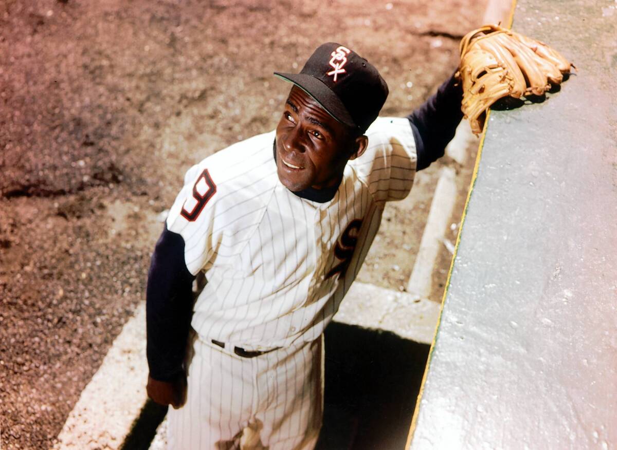Chicago White Sox star Minnie Minoso poses outside the Comiskey Park dugout in 1960.