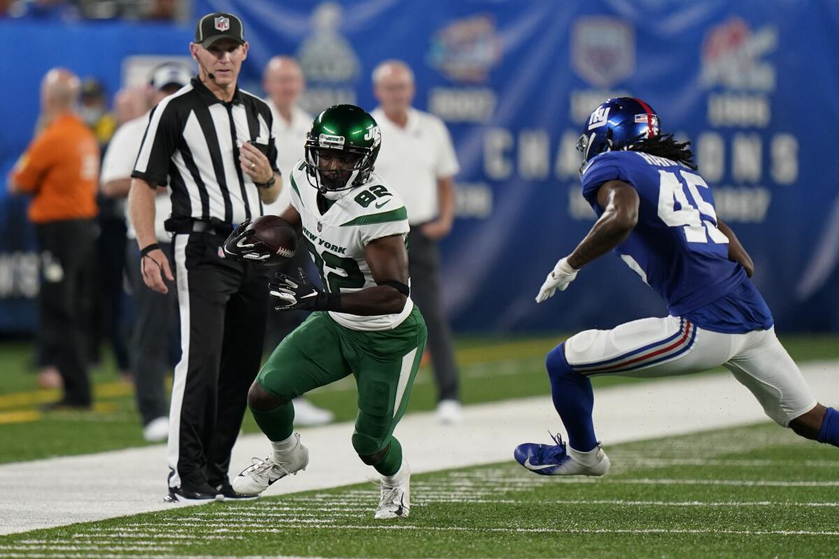 New York Jets wide receiver Jamison Crowder (82) runs the ball next to New York Giants cornerback Madre Harper (45) during the first half of an NFL preseason football game Saturday, Aug. 14, 2021, in East Rutherford, N.J. (AP Photo/Corey Sipkin)