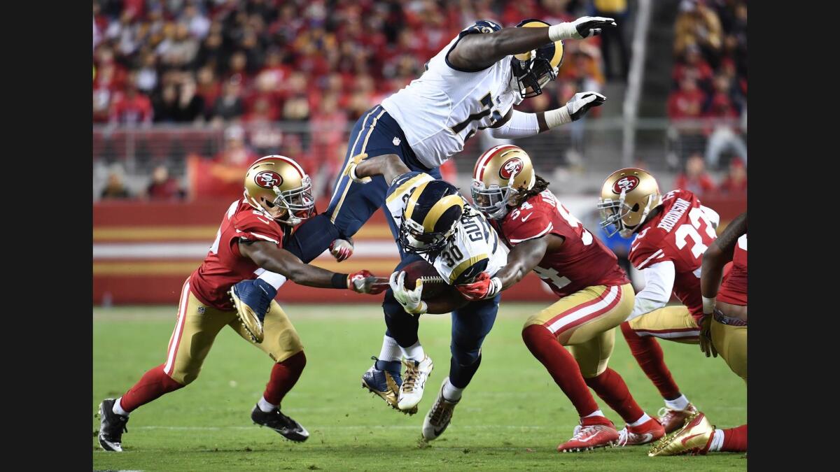 Rams running back Todd Gurley is brought down by the 49er defense as offensive lineman Greg Robinson tries to avoid him in the 3rd quarter.
