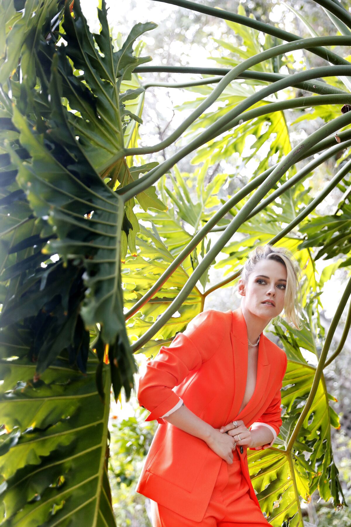 Kristen Stewart poses for a portrait surrounded by palm fronds.