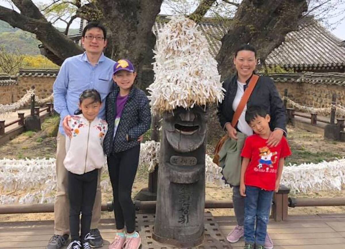 Nellie Sung, right, and her family stand in front of an ancient temple and statues during a trip to Korea.