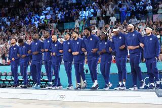 American basketball players celebrate their win against France in the gold-medal match Saturday in Paris.