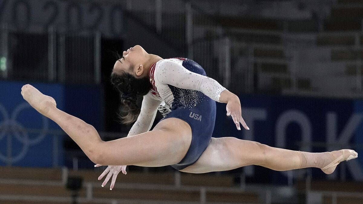 A gymnast performs splits in the air as part of a routine.