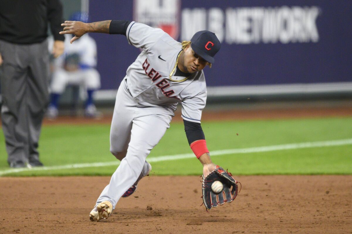 Cleveland Indians third baseman Jose Ramirez scoops up this grounder to throw out Kansas City Royals' Whit Merrifield for the third out in the sixth inning of a baseball game Tuesday, May 4, 2021, in Kansas City, Mo. (AP Photo/Reed Hoffmann)