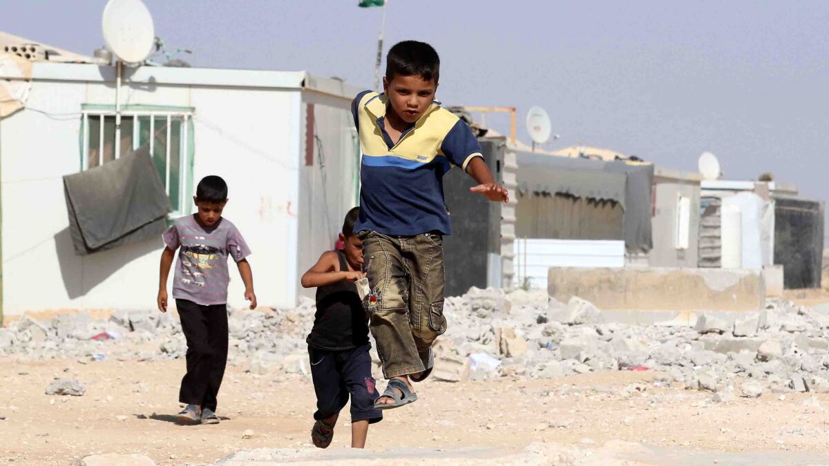 Syrian refugee children play at the Zaatari refugee camp, located close to the northern Jordanian city of Mafraq near the border with Syria.