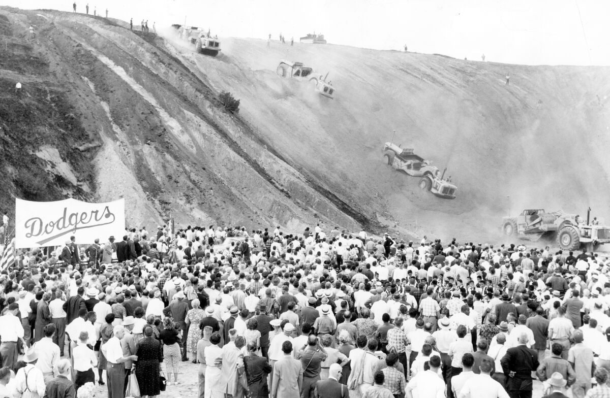 A crowd watches in 1959 as trucks and tractors roll over what would become Dodger Stadium