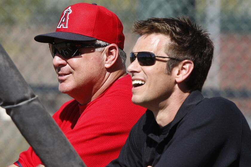 Angels Manager Mike Scioscia, left, and General Manager Jerry Dipoto watch batting practice during spring training.