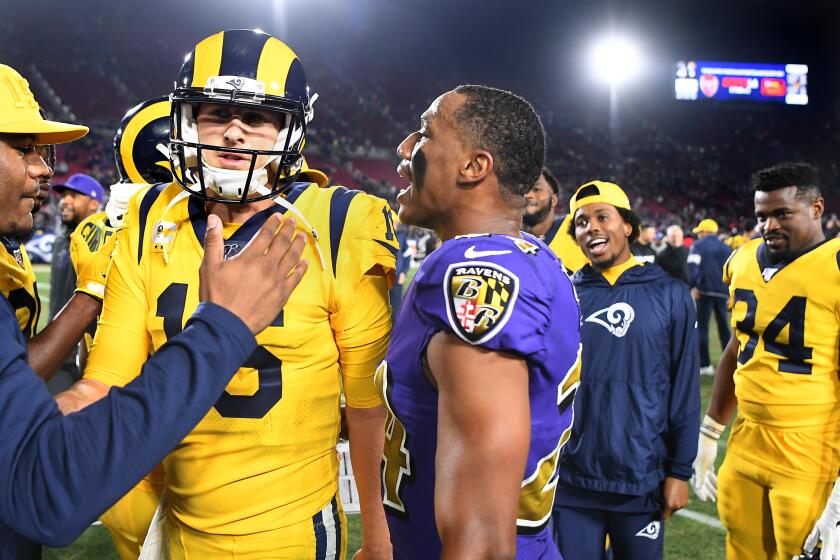 LOS ANGELES, CALIFORNIA NOVEMBER 25, 2019-Ravens Marcus Peters talks to Rams quarterback Jared Goff as they leave the field after the game at the Coliseum Sunday. (Wally Skalij/Los Angerles Times)