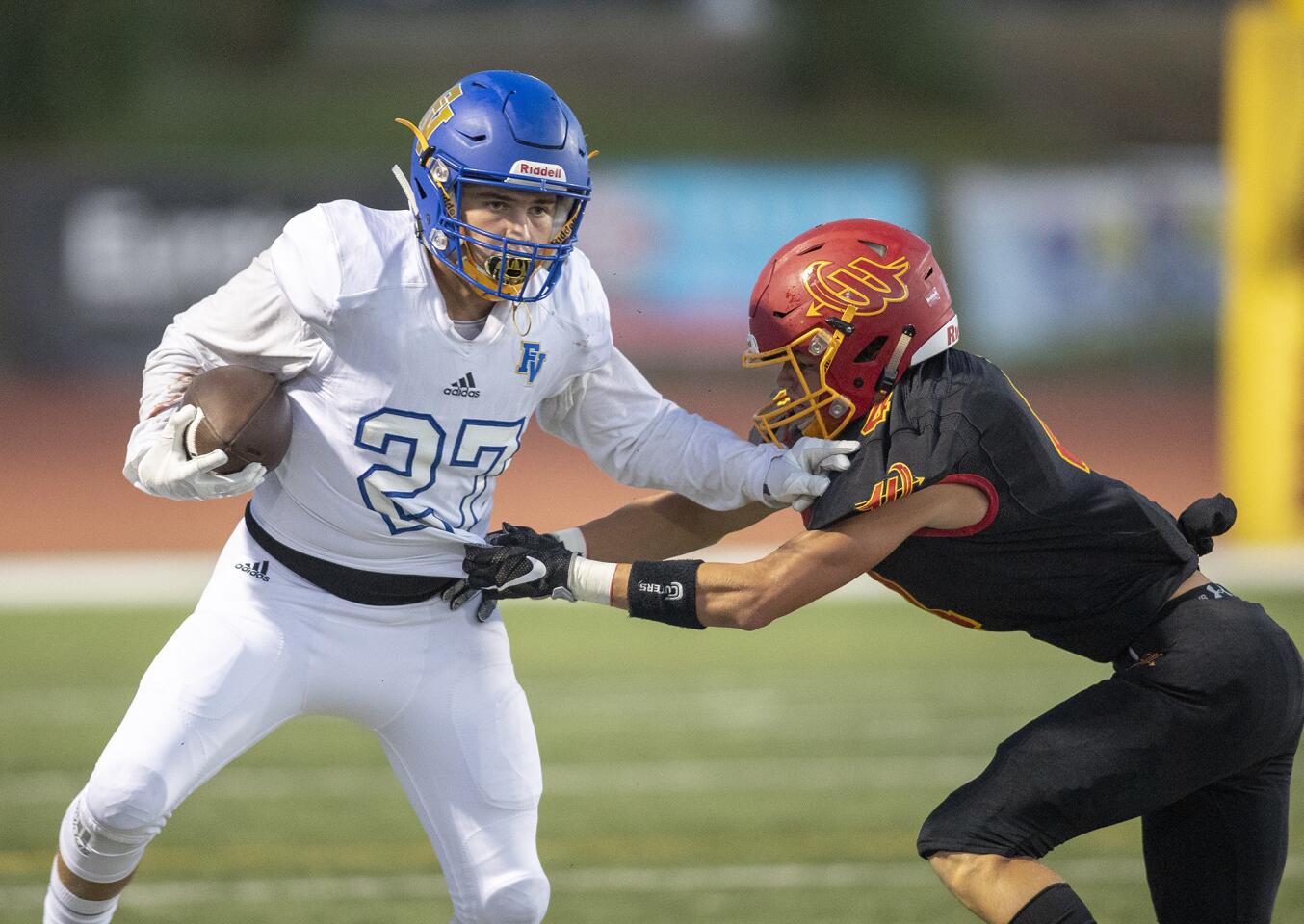 Woodbridge's Ezra Aguirre attempts to wrap up Fountain Valley's Brandon Krause during a nonleague game at University High School on Friday, August 31.