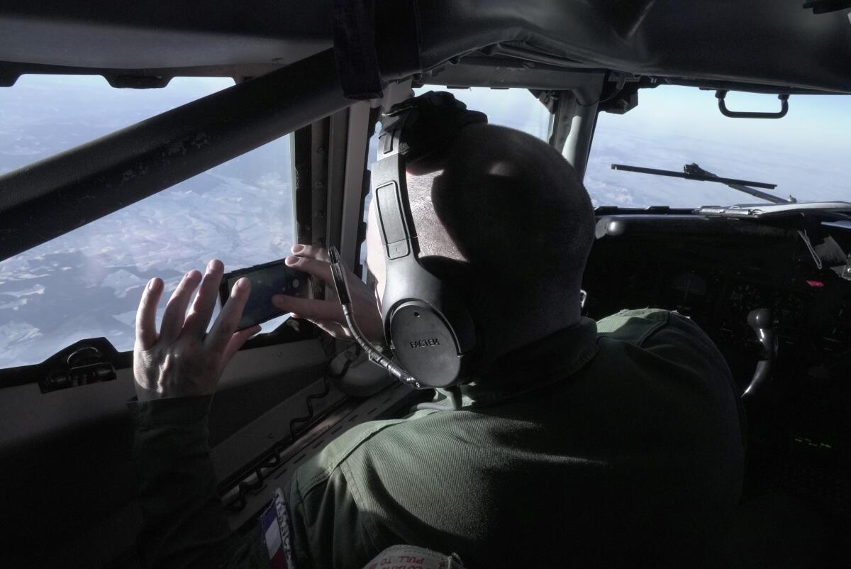 A crew member snaps a souvenir photo from the cockpit of a French military AWACS surveillance plane.