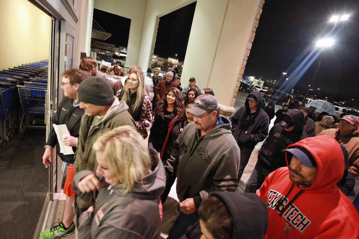 Consumidores corren a través de la entrada a la tienda Academy Sports+Outdoors a las 5:00 de la mañana en el centro comercial Chimney Rock Shopping el viernes 27 de noviembre de 2015 en Odessa, Texas. (Jacob Ford/Odessa American vía AP)