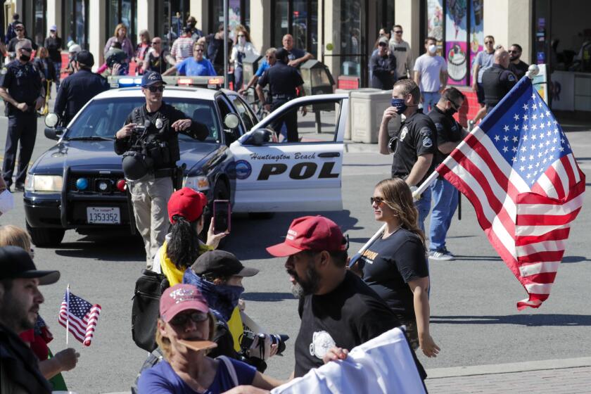 HUNTINGTON BEACH, CA - APRIL 17: A big number of Trump supporters rally on Main Street against business closure due to COVID-19 pandemic. Huntington Beach, CA. (Irfan Khan / Los Angeles Times)