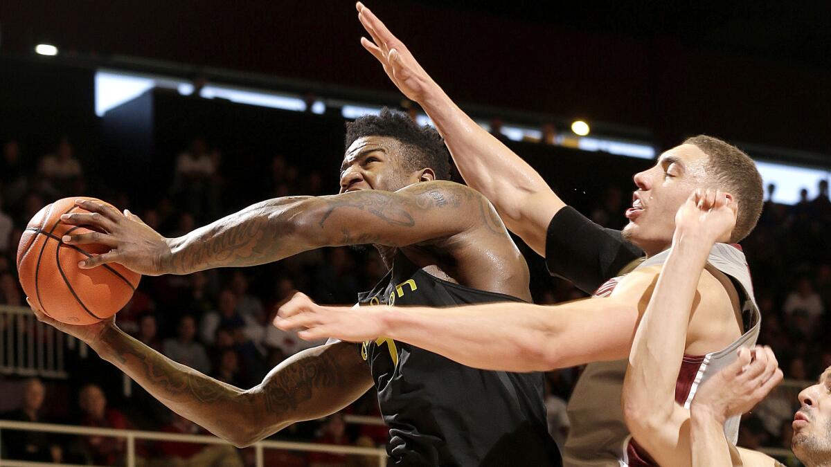 Oregon forward Jordan Bell tries to power his way to the basket against Stanford forward Reid Travis during the first half Saturday.