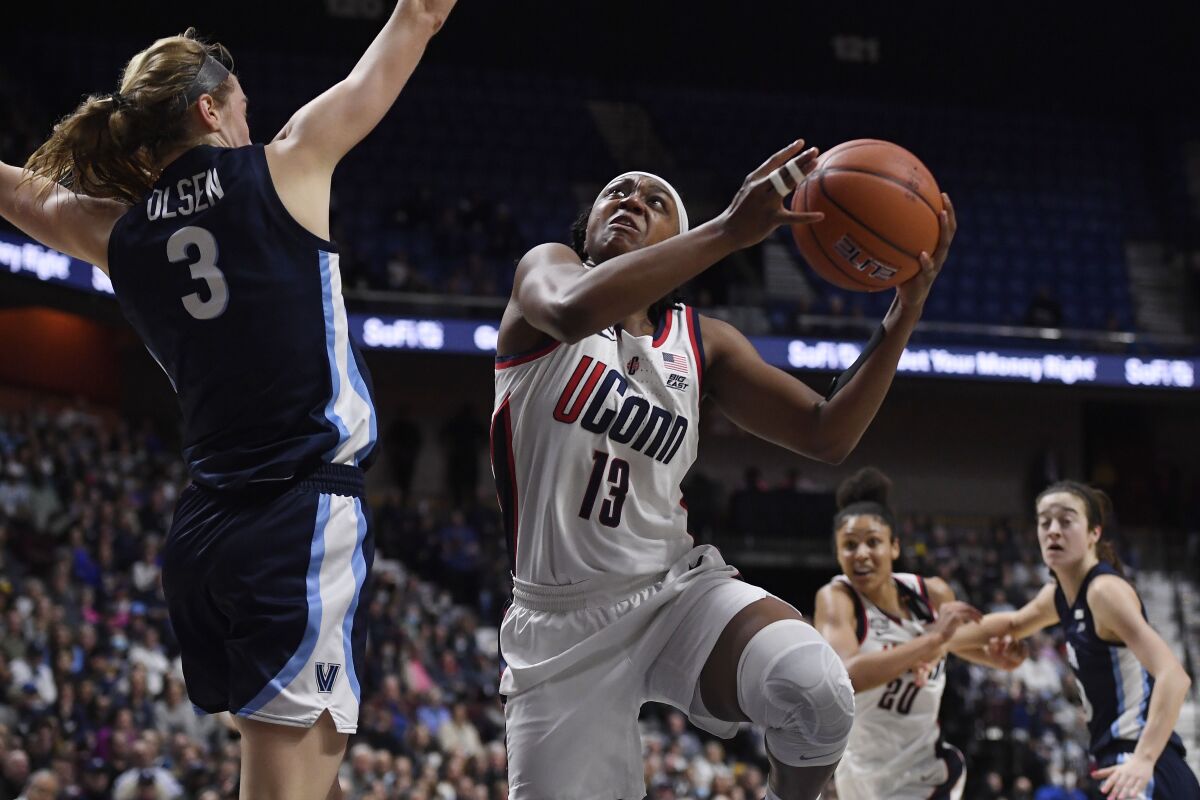 Connecticut's Christyn Williams (13) shoots as Villanova's Lucy Olsen (3) defends in the first half of an NCAA college basketball game in the Big East tournament finals at Mohegan Sun Arena, Monday, March 7, 2022, in Uncasville, Conn. (AP Photo/Jessica Hill)