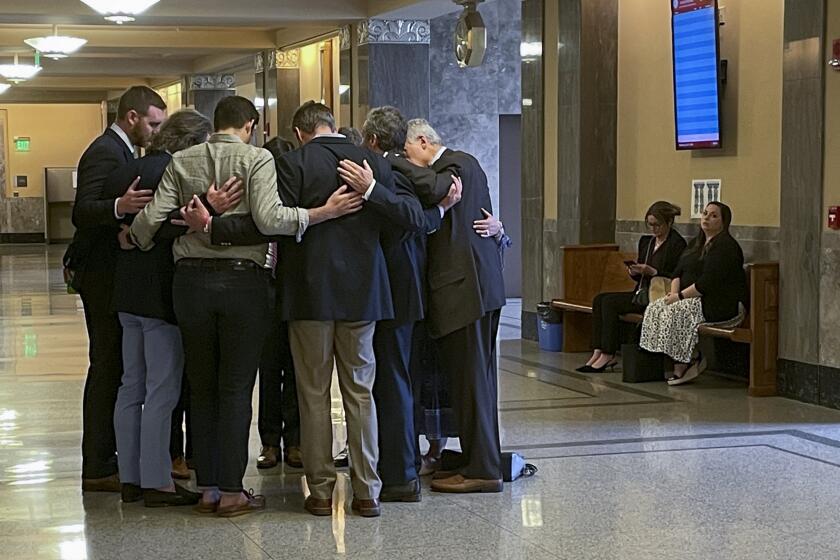 Covenant School parents and their attorneys huddle in prayer outside a courtroom before a hearing to decide whether documents and journals of a Nashville school shooter can be released to the public Wednesday, April 17, 2024, in Nashville, Tenn. A Tennessee judge will soon decide whether the journals of a Nashville school shooter can be released to the public, after nearly a year of legal wrangling over who can participate in the case. (AP Photo/Travis Loller)