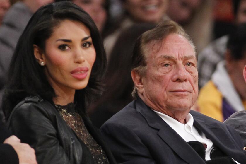 Clippers owner Donald Sterling, right, and V. Stiviano watch the Clippers play the Lakers in a 2010 preseason game. What possible steps could the NBA take if it chooses to punish Sterling for racist comments he allegedly made?