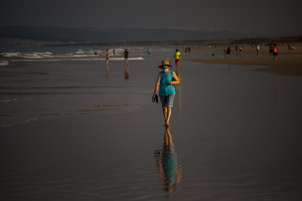 Woman walks on beach in Cadiz province, Spain