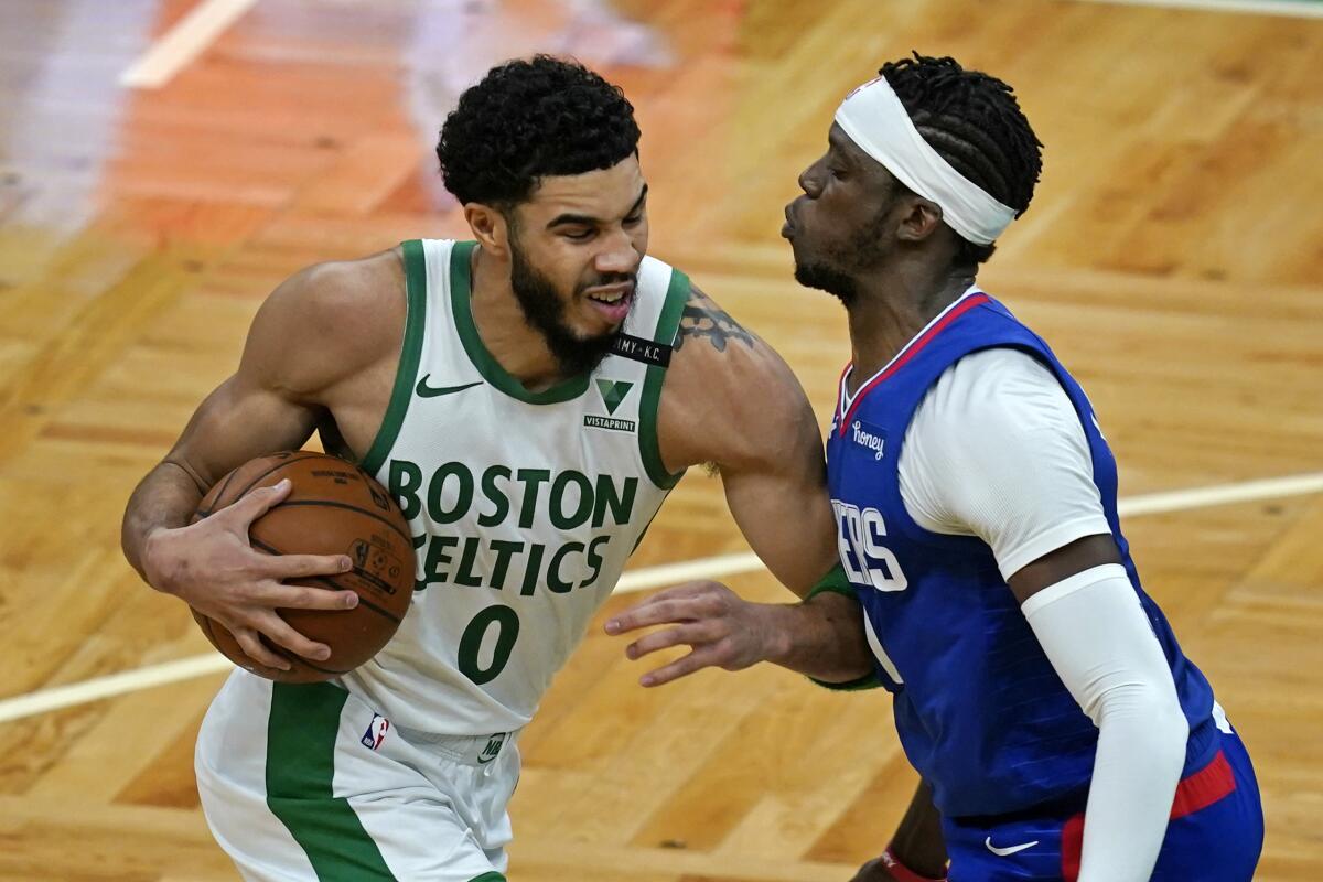 Jayson Tatum, alero de los Celtics de Boston, trata de avanzar ante Reggie Jackson.