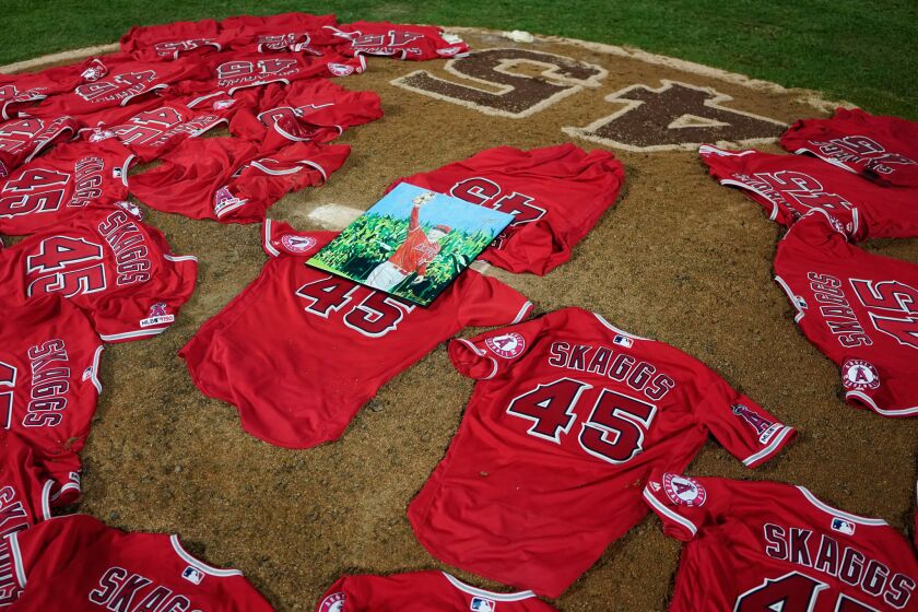 A portrait of the late Angels pitcher Tyler Skaggs sits atop the jerseys on the pitcher's mound after the Angels no-hitted the Mariners.