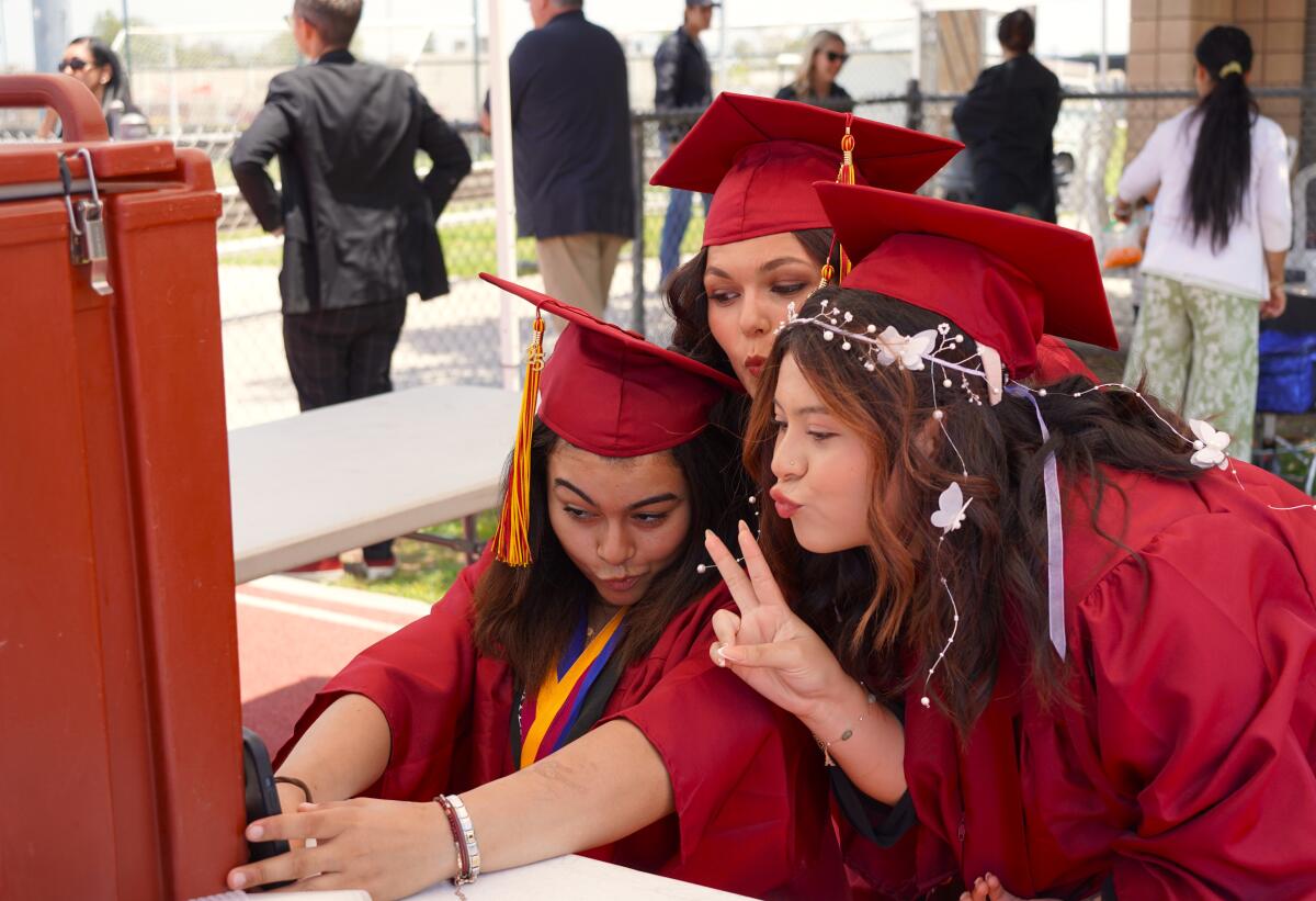 A trio of friends pose for selfies Thursday before Estancia High School's graduation ceremony on the Costa Mesa campus.