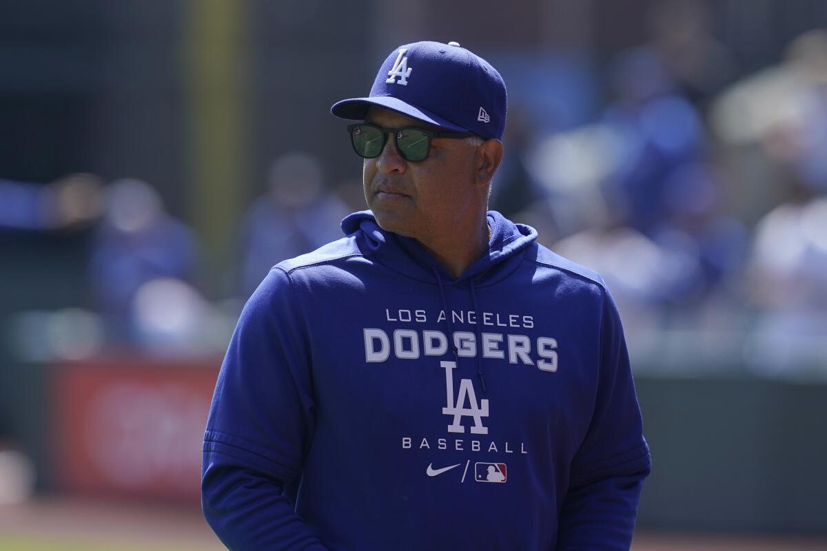 Dodgers manager Dave Roberts stands on the field before a game against the Giants on Aug. 4.