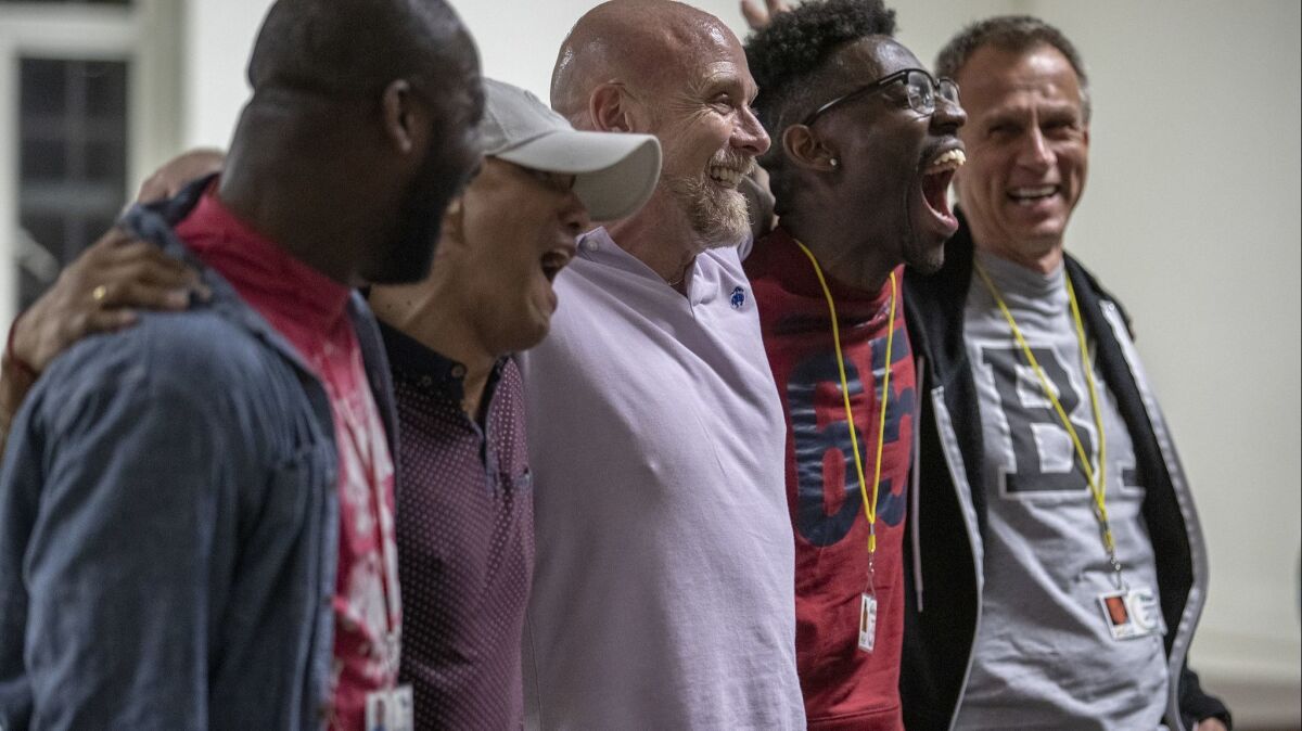 Brandon Singleton, second from right, and Shawn Ingram, third from right, share a lighter moment during rehearsal for the Gay Men's Chorus of Los Angeles.