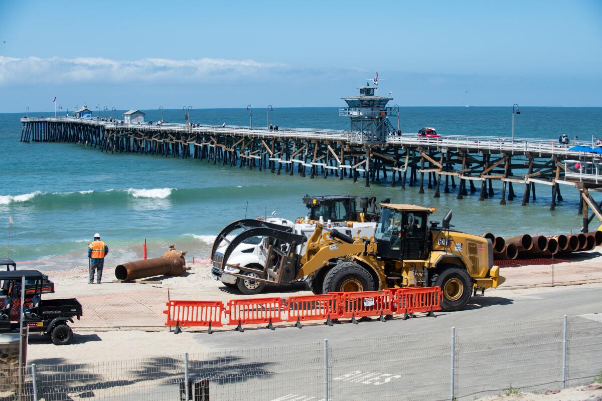 Crews overseen by the U.S. Army Corps of Engineers are pumping sand on the beach south of San Clemente's pier.