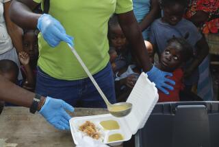 FILE - A server ladles soup into a container as children line up to receive food at a shelter for families displaced by gang violence, in Port-au-Prince, Haiti, March 14, 2024. Gang violence in Haiti has displaced over 300,000 children since March, according to a new report from the U.N. children's agency released late Tuesday, July 2, as the Caribbean country struggles to curb killings and kidnappings. (AP Photo/Odelyn Joseph, File)