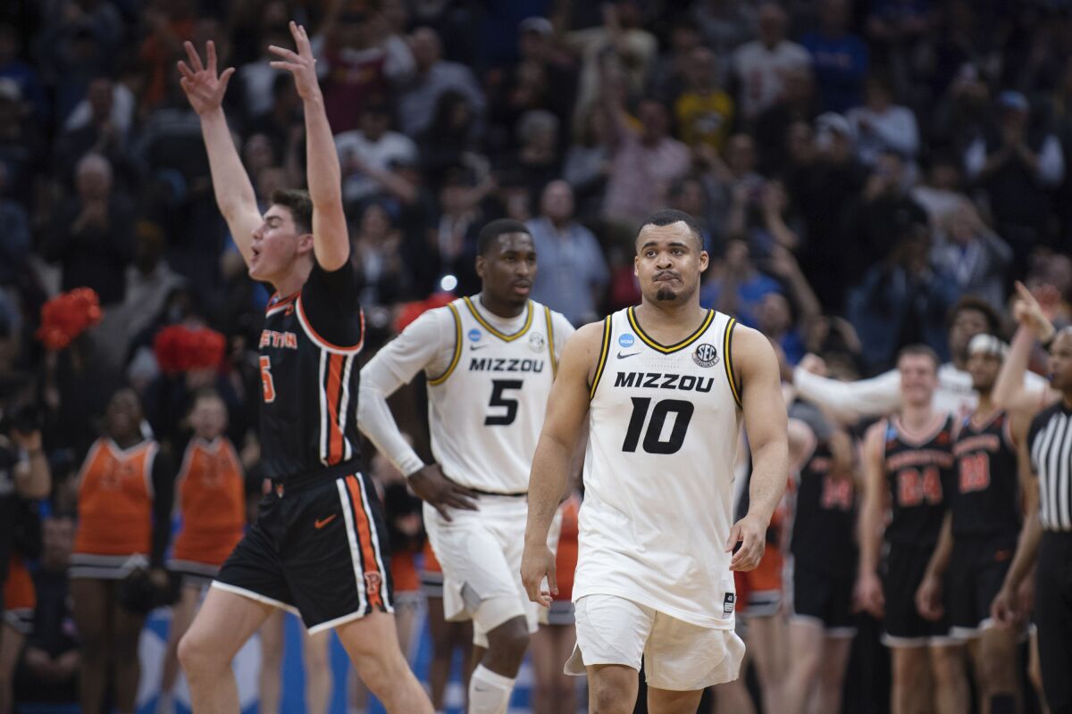 Missouri's Nick Honor (10) and D'Moi Hodge (5) leave the floor as Princeton's Jack Scott (5) celebrates the Tigers' victory.