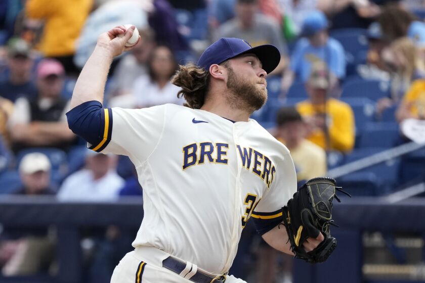 Milwaukee Brewers starting pitcher Corbin Burnes throws to a Cincinnati Reds batter during the first inning of a spring training baseball game Sunday, March 19, 2023, in Phoenix. (AP Photo/Ross D. Franklin)