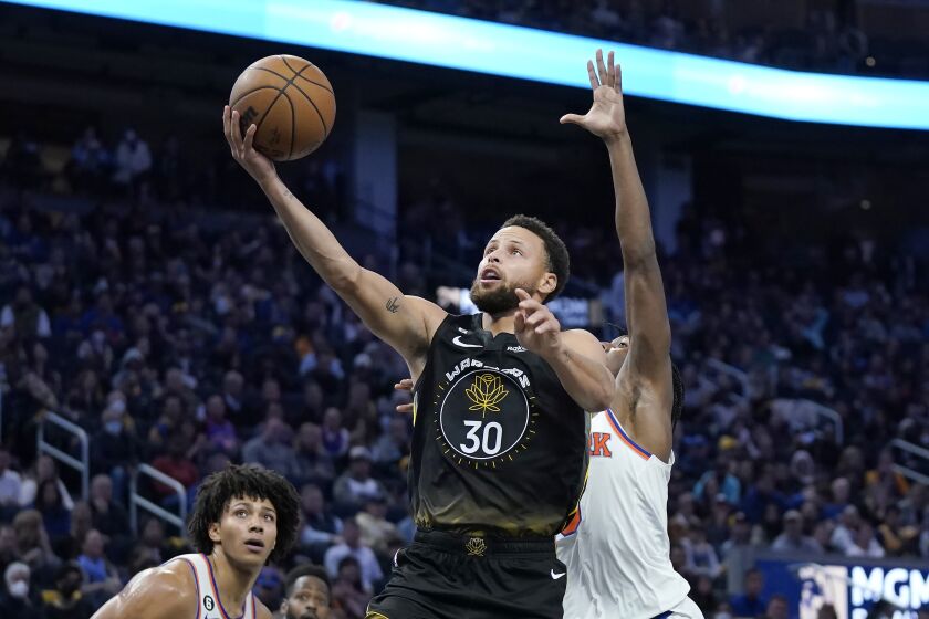Stephen Curry de los Warriors de Golden State lanza ante el base de los Knicks de Nueva York, Immanuel Quickley, durante la segunda parte del juego de la NBA, el viernes 18 de noviembre de 2022, en San Francisco. (AP Foto/Jeff Chiu)